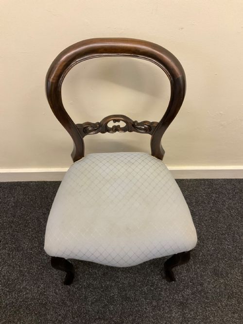 fig 8. A set of six Victorian mahogany dining chairs featuring rounded balloon backs, central carved splats, light blue upholstered seats, and cabriole front legs.