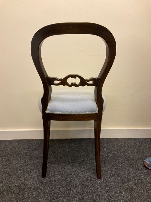 fig 9. A set of six Victorian mahogany dining chairs featuring rounded balloon backs, central carved splats, light blue upholstered seats, and cabriole front legs.