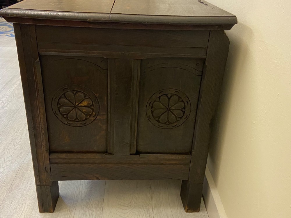 An 18th-century dark oak coffer with a flat rectangular top and four recessed front panels resting on extended stile feet. View III