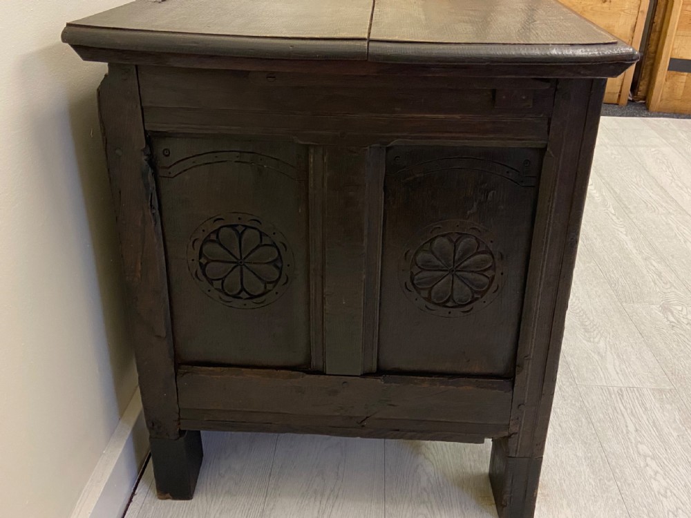 An 18th-century dark oak coffer with a flat rectangular top and four recessed front panels resting on extended stile feet. View IV