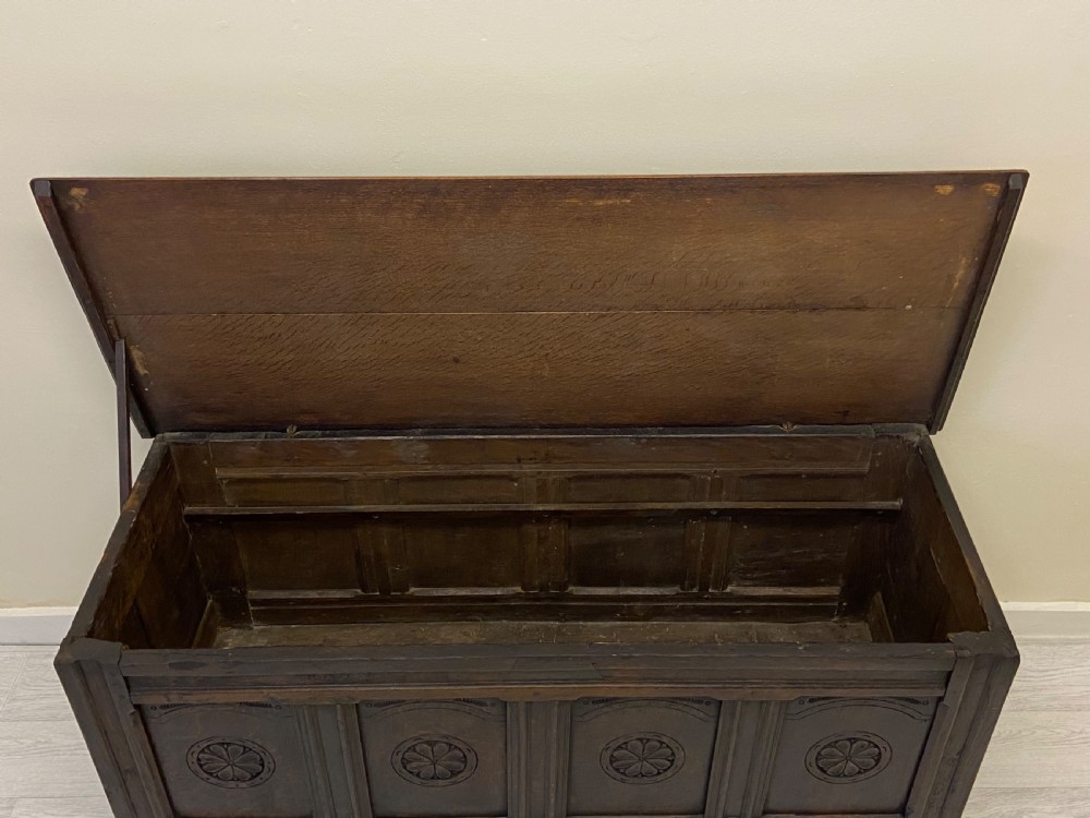 An 18th-century dark oak coffer with a flat rectangular top and four recessed front panels resting on extended stile feet. View VI