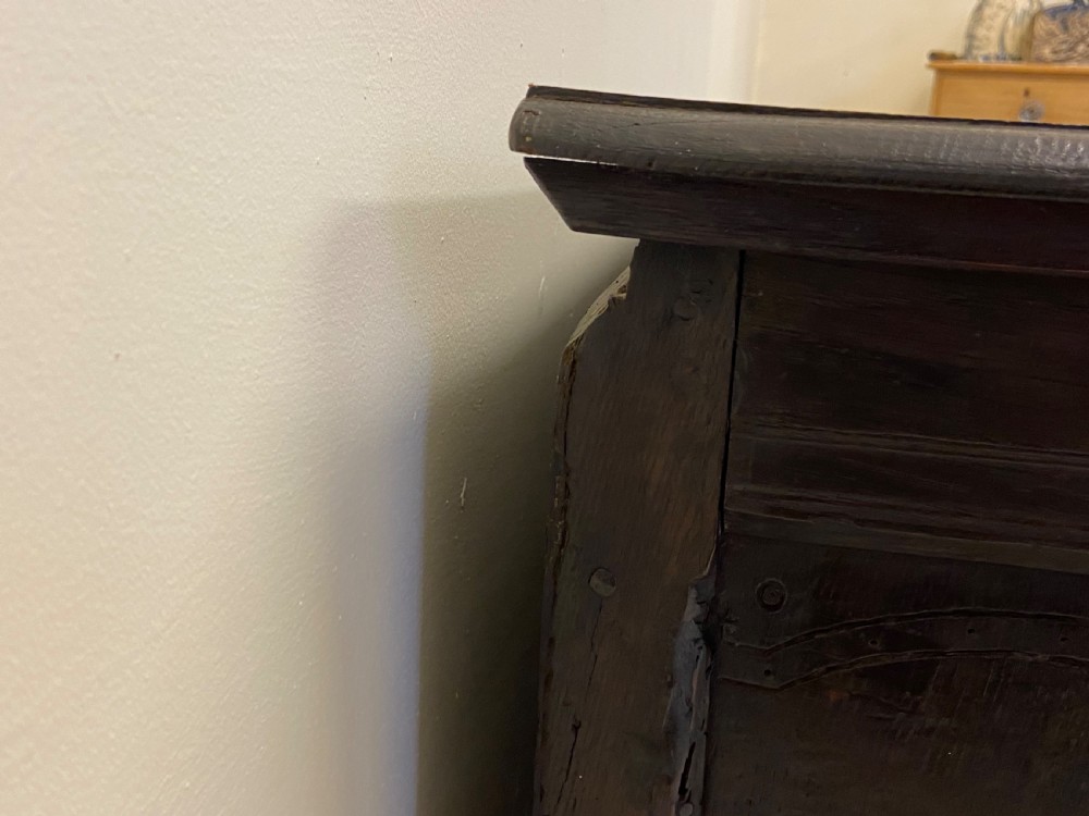 An 18th-century dark oak coffer with a flat rectangular top and four recessed front panels resting on extended stile feet. View VII