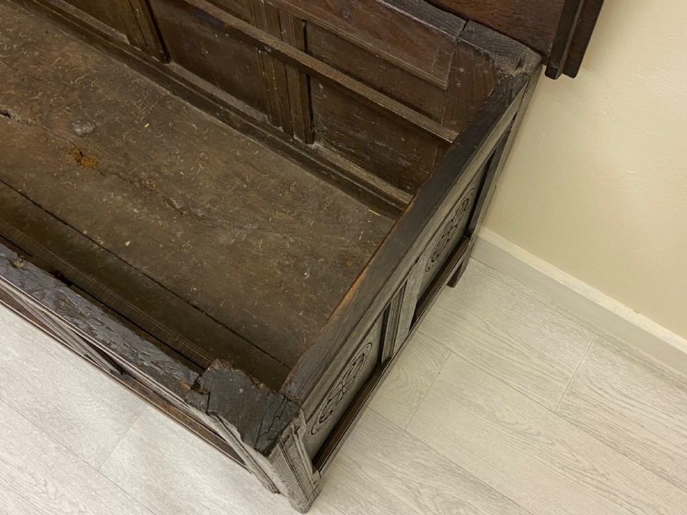 An 18th-century dark oak coffer with a flat rectangular top and four recessed front panels resting on extended stile feet. View X