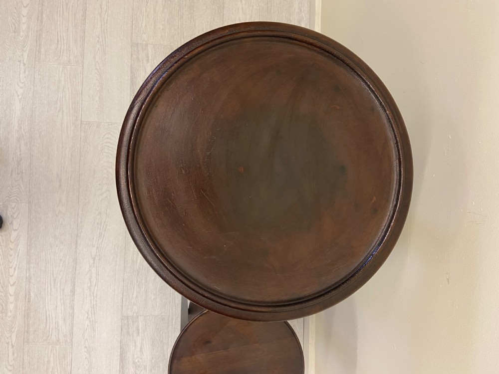 A non-matching pair of dark brown mahogany plant stands featuring circular tops, lower undertiers, and curved legs. View IV