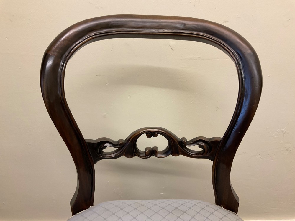 A set of six Victorian mahogany dining chairs featuring rounded balloon backs, central carved splats, light blue upholstered seats, and cabriole front legs. View XIV