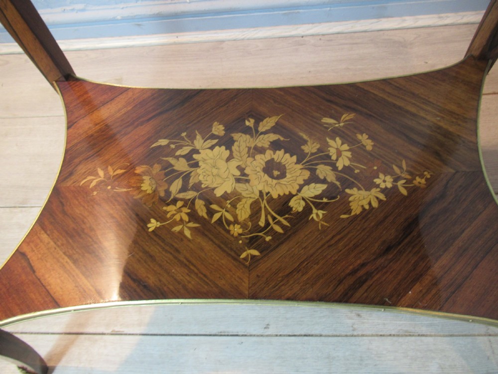 A 19th-century French rosewood bijouterie table featuring a glazed lift top, floral marquetry inlay, gilt bronze mounts, cabriole legs, and a lower shelf. View VI