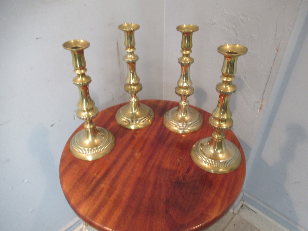 Set of four  large Victorian   brass candle sticks View II