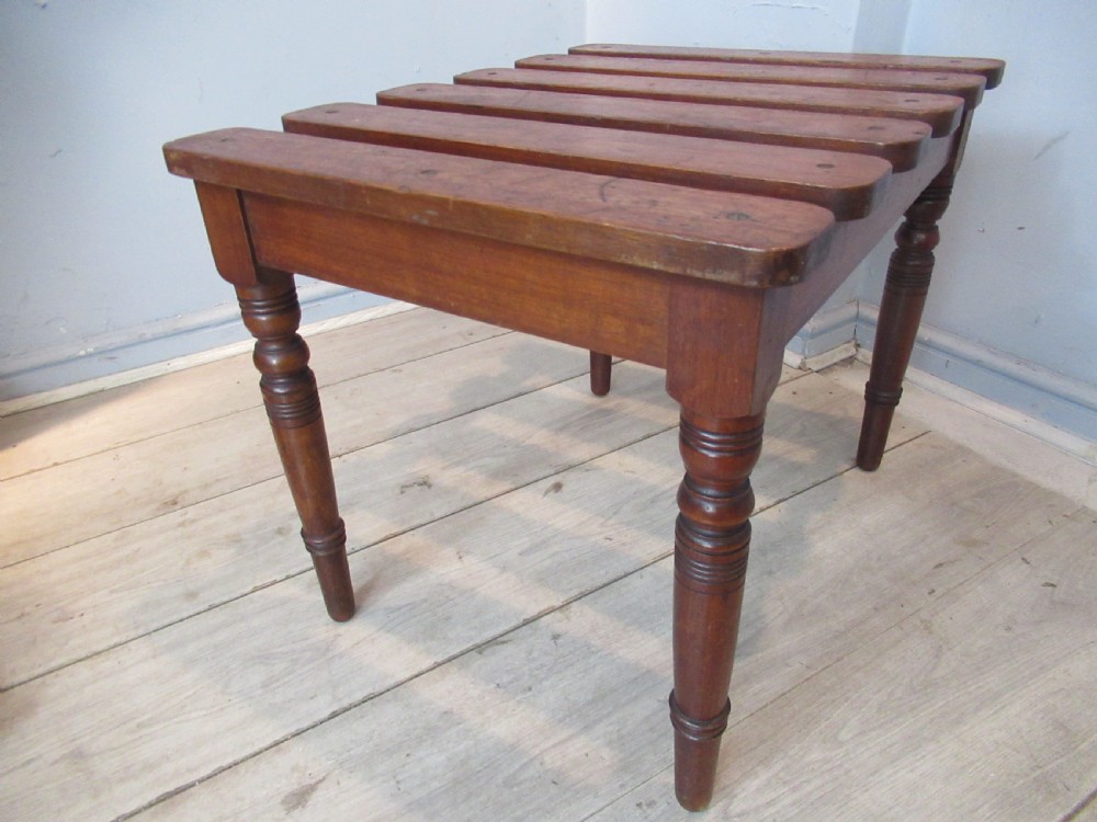 A late Victorian mahogany luggage stand featuring six rounded slatted top rails supported by a sturdy timber frame and four turned legs. View II