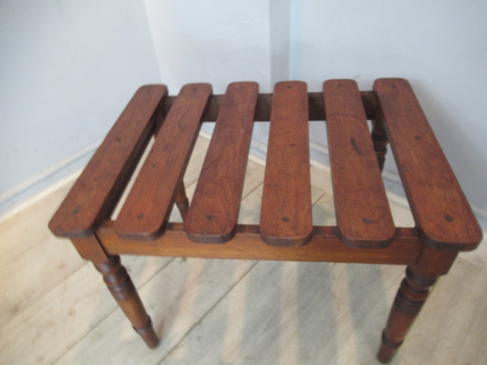A late Victorian mahogany luggage stand featuring six rounded slatted top rails supported by a sturdy timber frame and four turned legs. View III