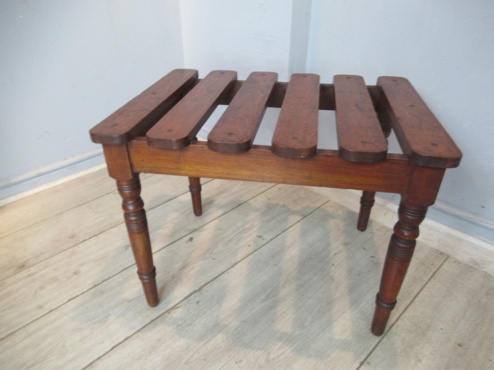 A late Victorian mahogany luggage stand featuring six rounded slatted top rails supported by a sturdy timber frame and four turned legs. View VIII