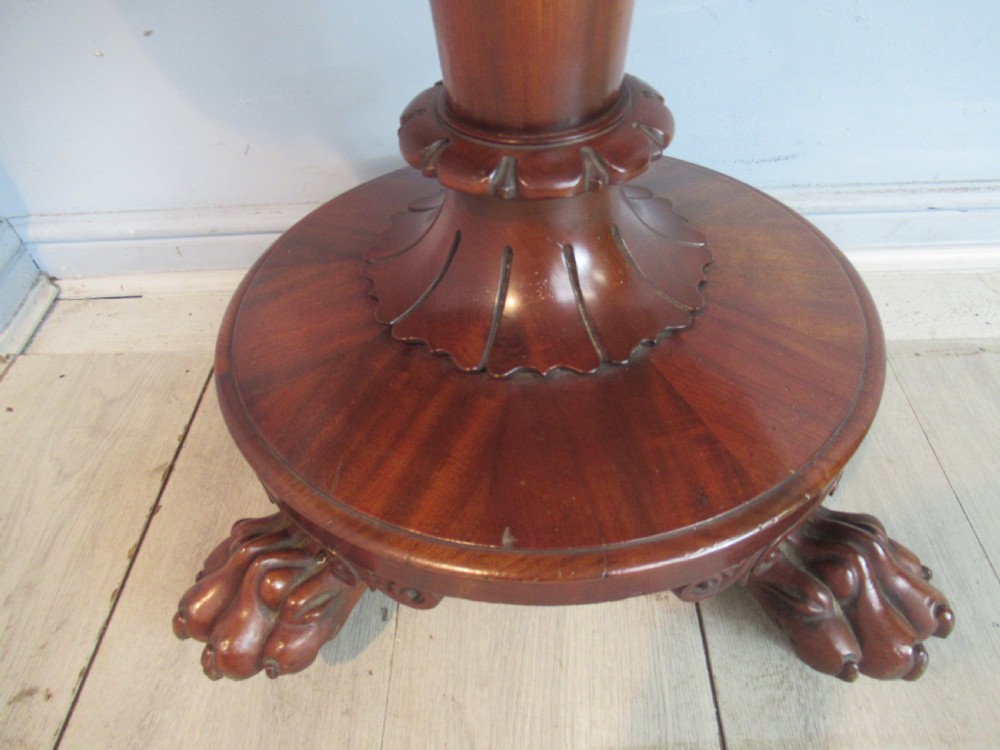A Victorian mahogany card table featuring a rectangular fold-over top, a central turned pedestal, and carved paw feet on a circular platform base. View III