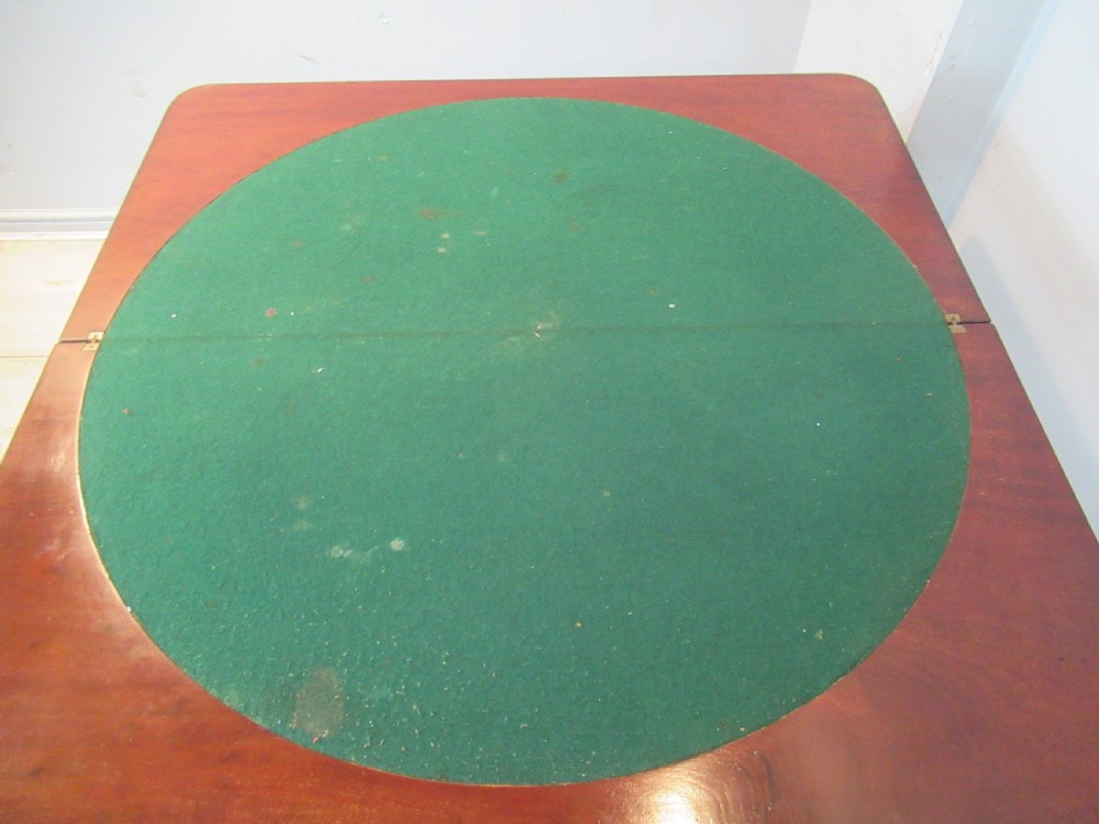 A Victorian mahogany card table featuring a rectangular fold-over top, a central turned pedestal, and carved paw feet on a circular platform base. View IX