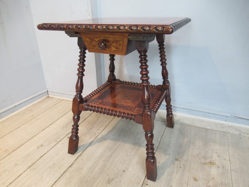 A 19th-century rich brown wood side table featuring a single drawer with marquetry inlay, carved bead edging, turned legs, and an inlaid lower shelf. View XI