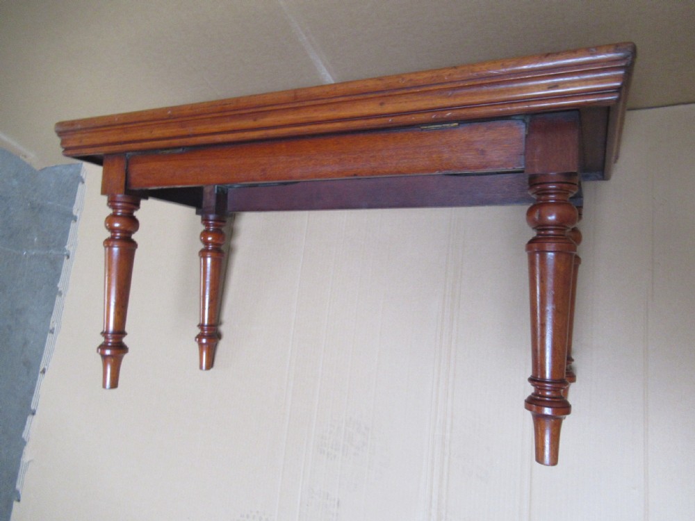 A low 19th-century mahogany folding campaign travel table featuring a tray top rim and turned legs. View II