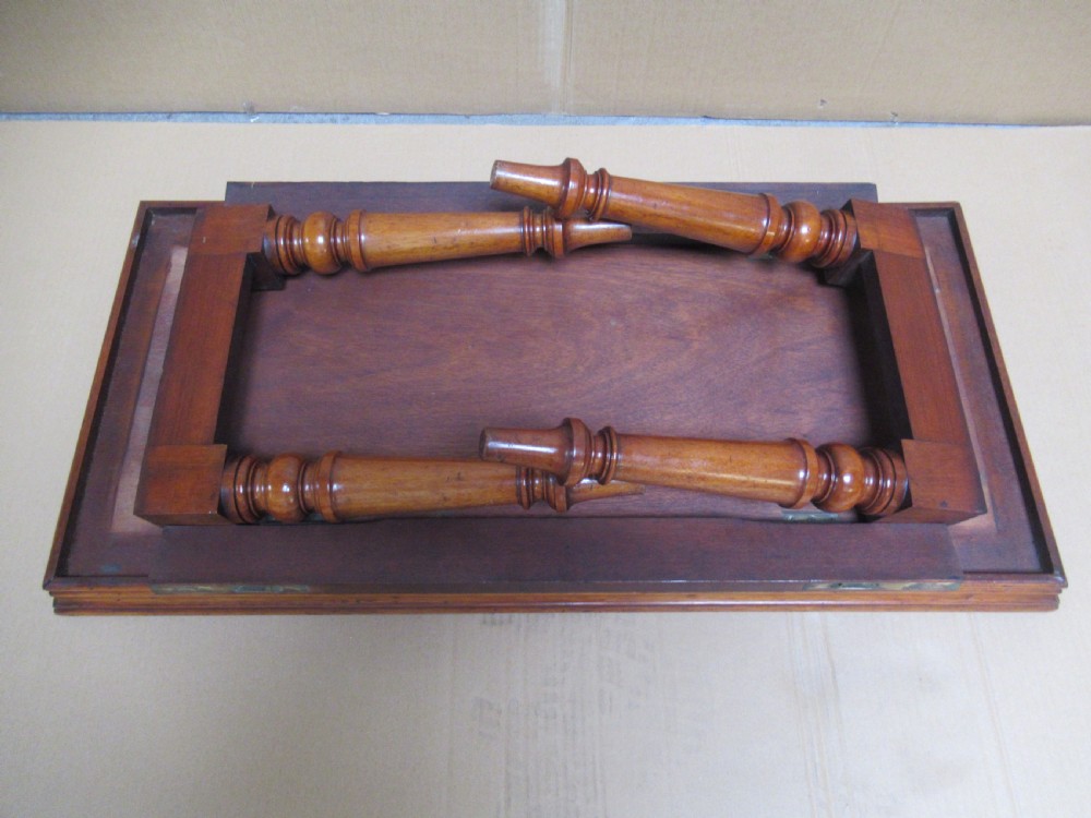 A low 19th-century mahogany folding campaign travel table featuring a tray top rim and turned legs. View V