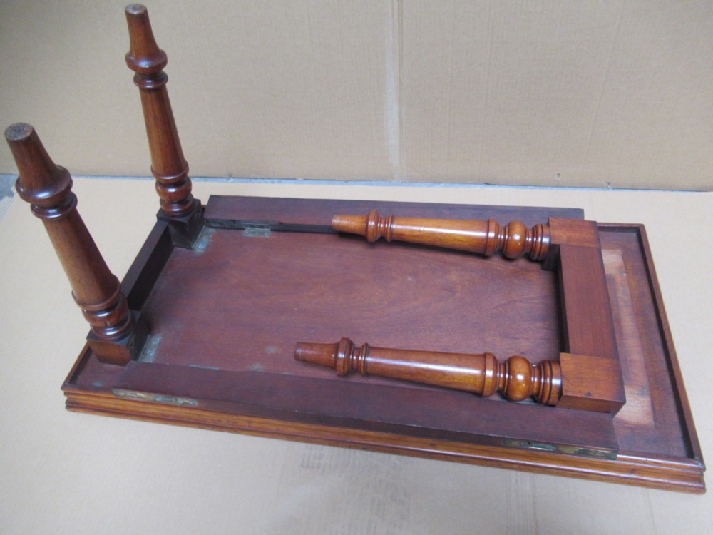 A low 19th-century mahogany folding campaign travel table featuring a tray top rim and turned legs. View X