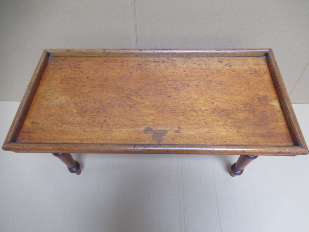 A low 19th-century mahogany folding campaign travel table featuring a tray top rim and turned legs. View XIV