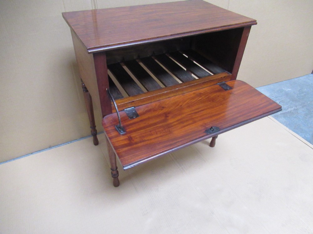 A Victorian mahogany side table featuring a drop-front door revealing an internal compartment with slatted support and turned wooden legs. View IX