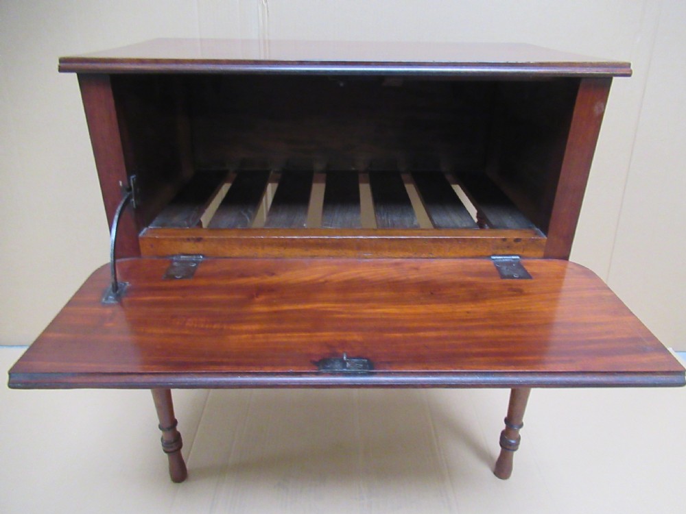 A Victorian mahogany side table featuring a drop-front door revealing an internal compartment with slatted support and turned wooden legs. View X