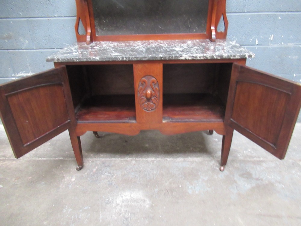 An Edwardian walnut washstand featuring a grey mottled marble top, double cupboards with burr walnut panels, and an oval mirror superstructure. View VII