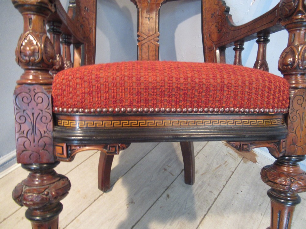 A set of three Victorian mahogany open armchairs with carved backrests, red upholstered seats, and turned front legs on brass castors. View VII