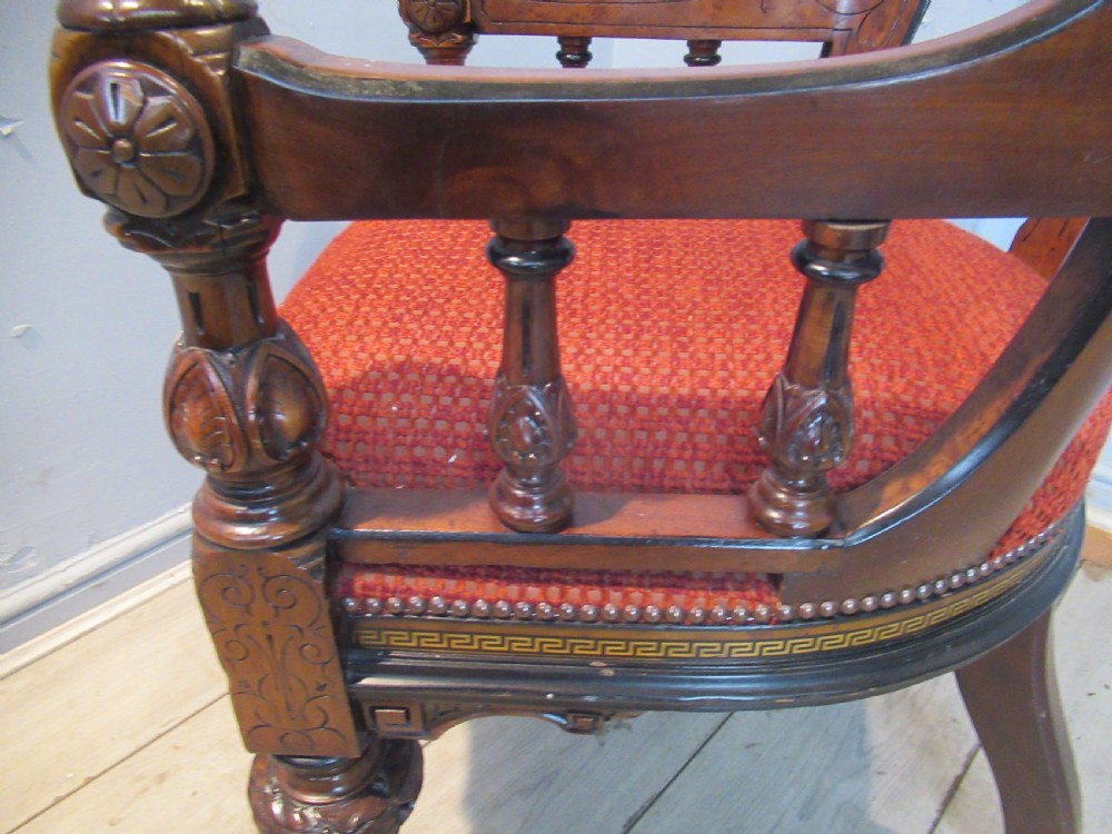A set of three Victorian mahogany open armchairs with carved backrests, red upholstered seats, and turned front legs on brass castors. View XIV