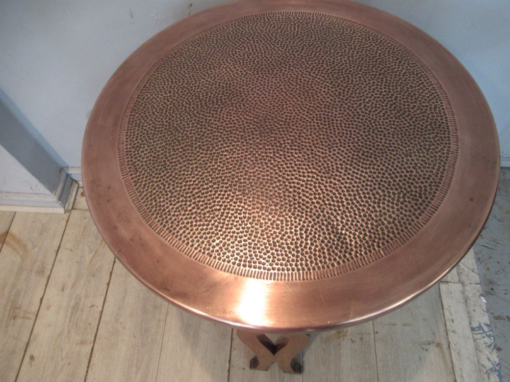 A circular Arts and Crafts oak side table featuring a hammered copper top insert and stylized shaped legs with a lower cross shelf. View V