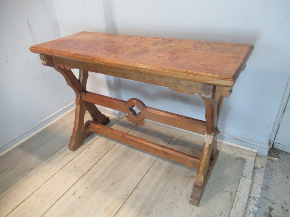 A Victorian pitch pine side table with a rectangular top, scalloped apron, and trestle supports joined by a stretcher with a carved quatrefoil motif. View III
