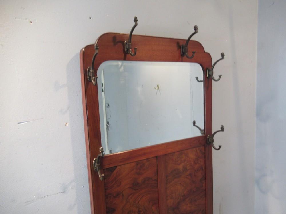 An antique walnut hall stand featuring an integrated mirror, multiple brass coat hooks, a central glove box, and a lower umbrella rack with metal drip trays. View III