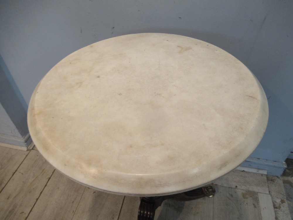A Regency period circular table featuring a white marble top supported by a reeded mahogany pedestal on a splayed tripod base with brass feet. View VII