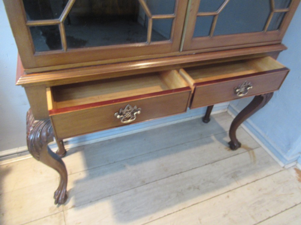 A Chippendale style mahogany glazed bookcase featuring geometric astragal doors, lower drawers, and carved cabriole legs ending in ball-and-claw feet. View IX