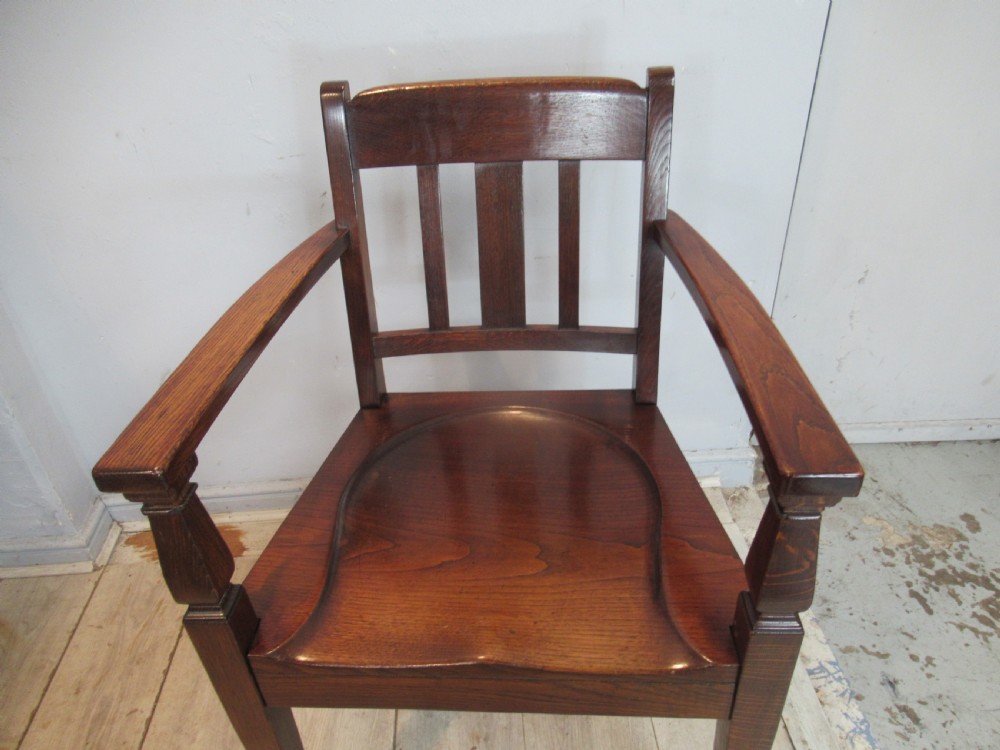 A pair of dark oak Arts and Crafts armchairs featuring vertical back slats, contoured solid timber seats, and straight tapered legs. View VI