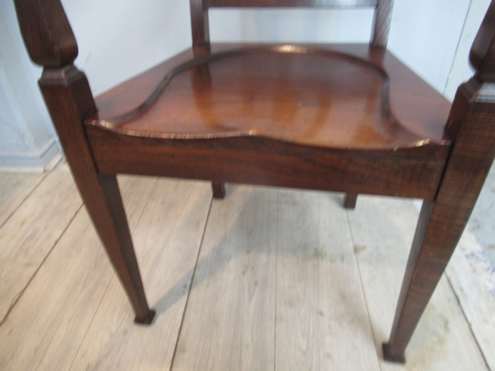 A pair of dark oak Arts and Crafts armchairs featuring vertical back slats, contoured solid timber seats, and straight tapered legs. View VIII