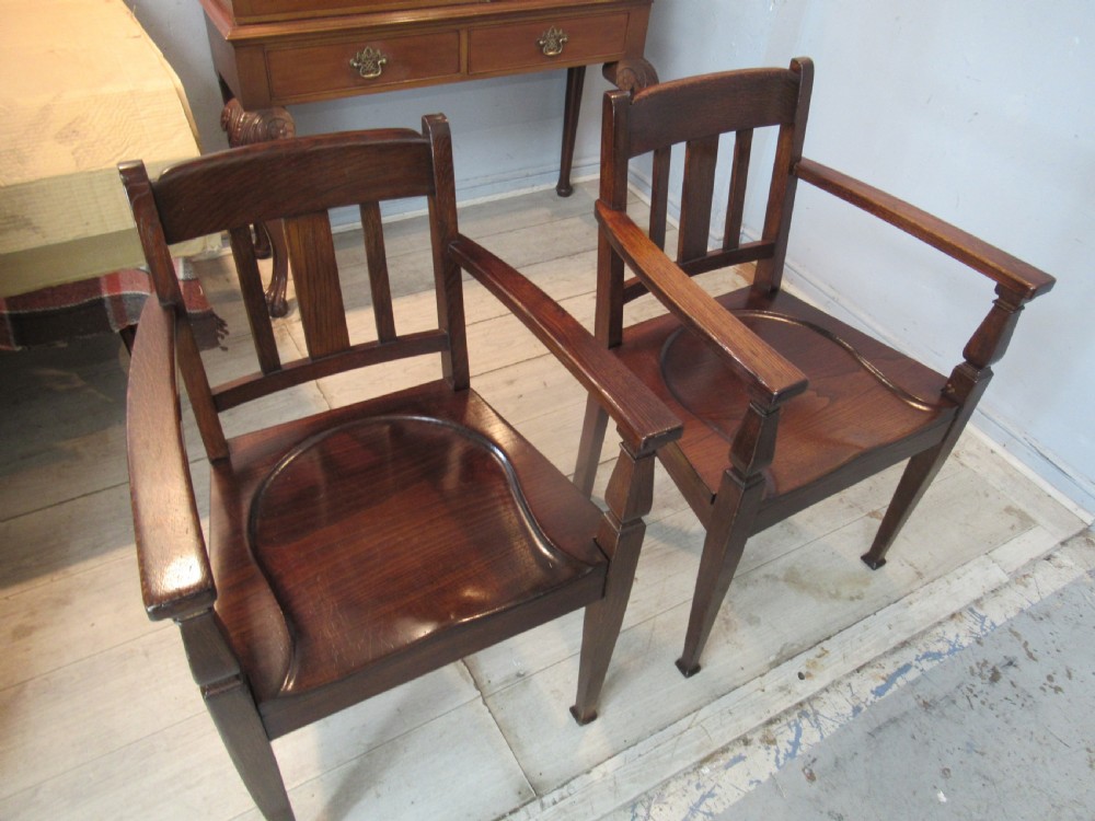 A pair of dark oak Arts and Crafts armchairs featuring vertical back slats, contoured solid timber seats, and straight tapered legs. View XII
