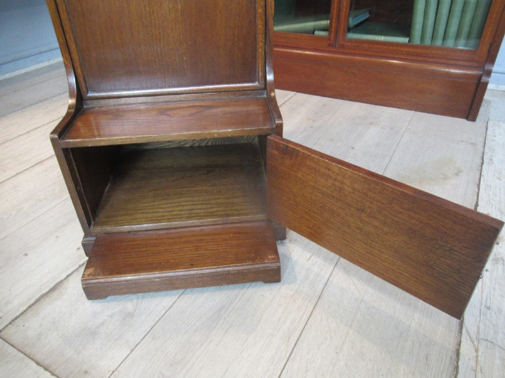A 1920s warm brown oak magazine rack featuring an integrated cantilevered folding reading table top. View VII