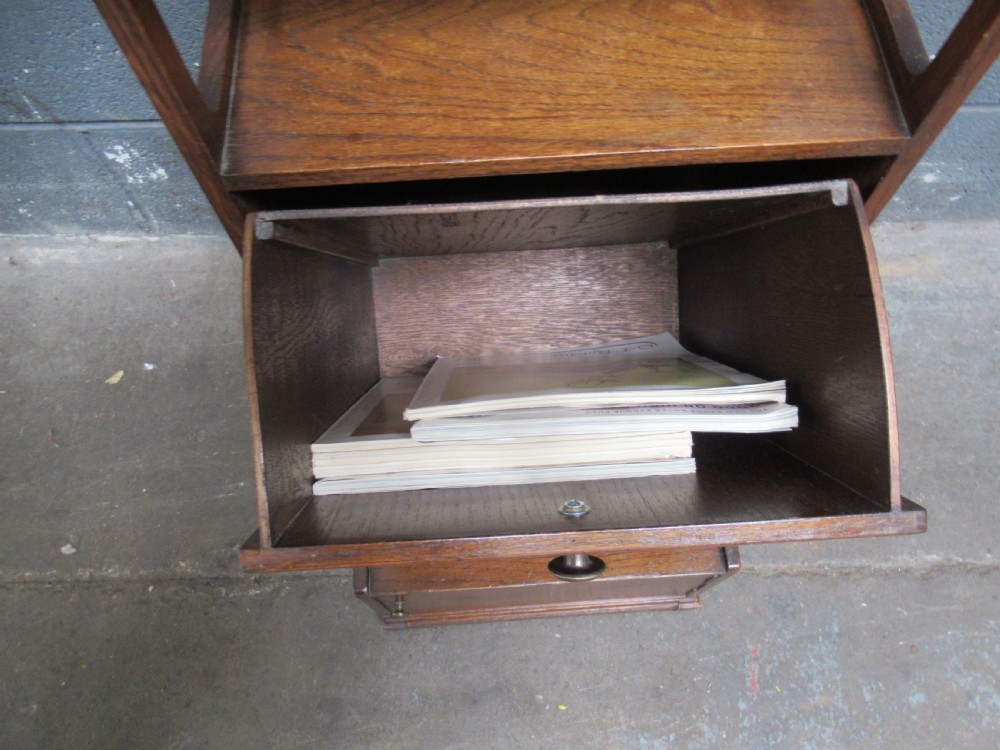 A 1920s warm brown oak magazine rack featuring an integrated cantilevered folding reading table top. View IX