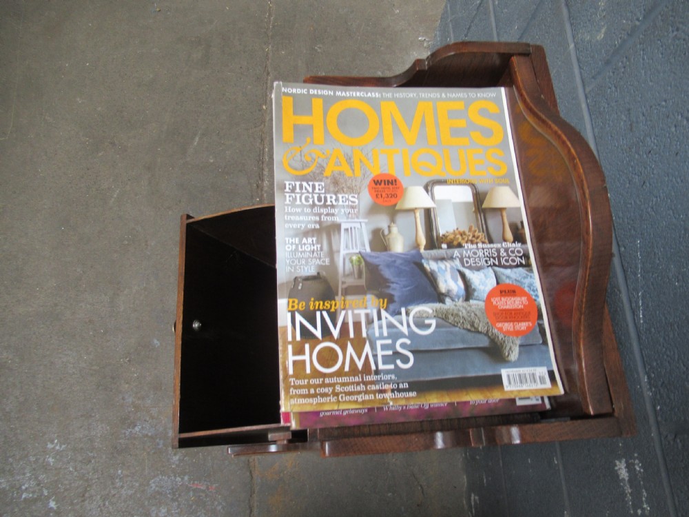 A 1920s warm brown oak magazine rack featuring an integrated cantilevered folding reading table top. View X