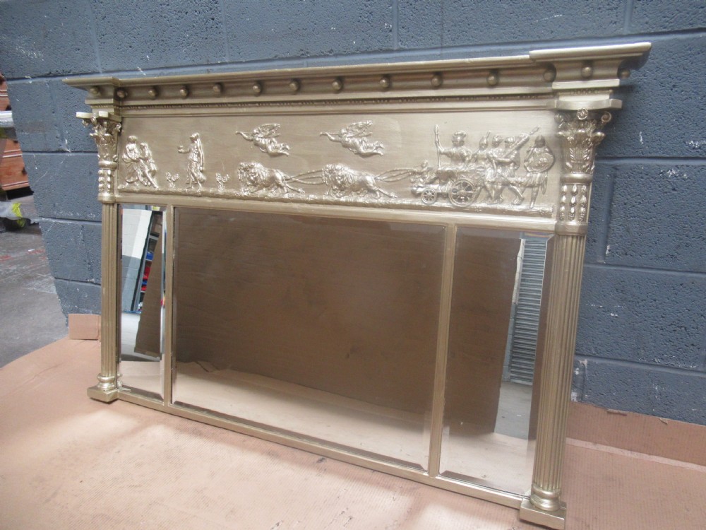 A 19th-century Regency gilt overmantel mirror featuring a detailed classical relief frieze, fluted side columns, and three glass mirror panels. View II