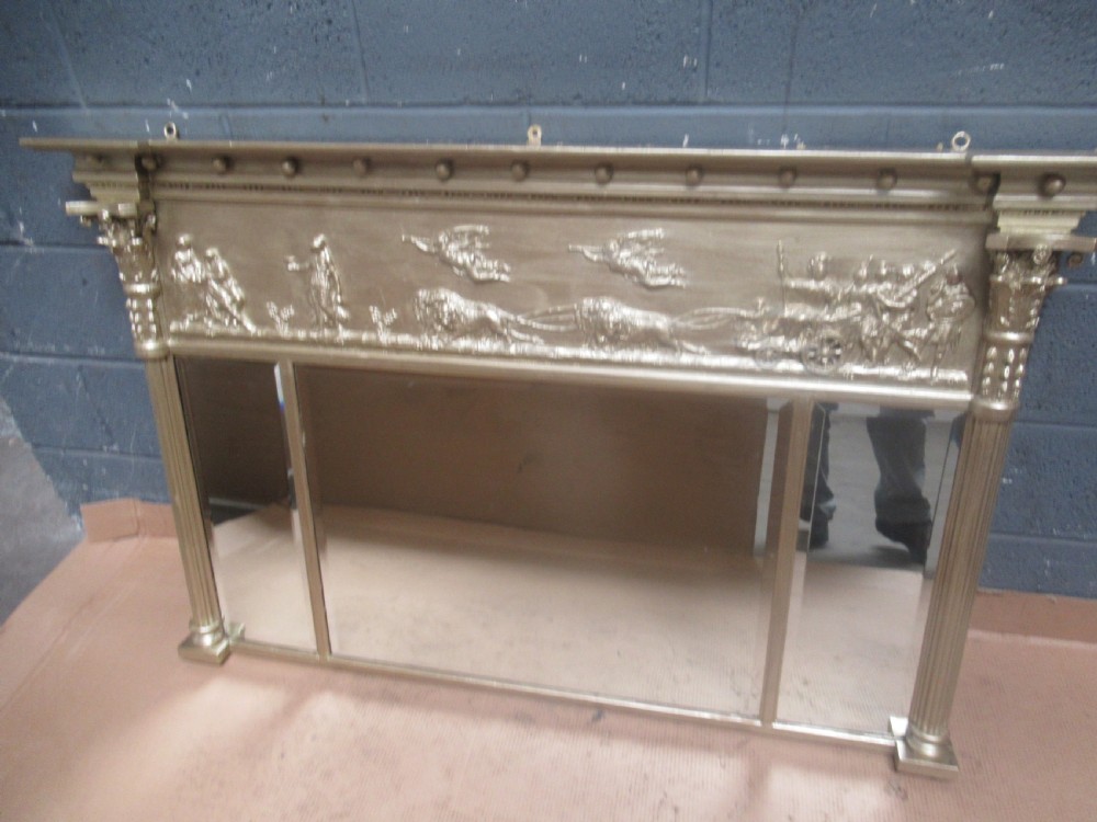 A 19th-century Regency gilt overmantel mirror featuring a detailed classical relief frieze, fluted side columns, and three glass mirror panels. View III