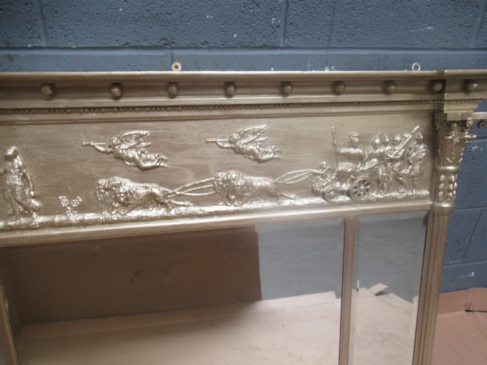 A 19th-century Regency gilt overmantel mirror featuring a detailed classical relief frieze, fluted side columns, and three glass mirror panels. View IX