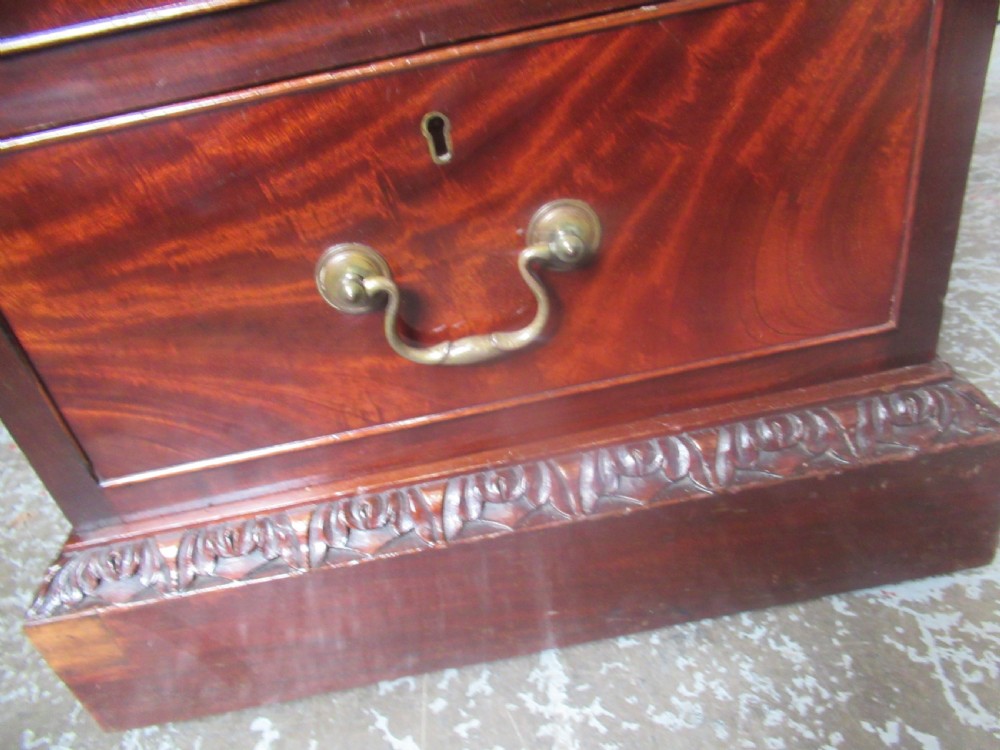 A large mahogany Georgian style pedestal desk featuring a dark green leather writing surface, brass swan-neck handles, and carved rope-twist moulding along the top edge. View VII