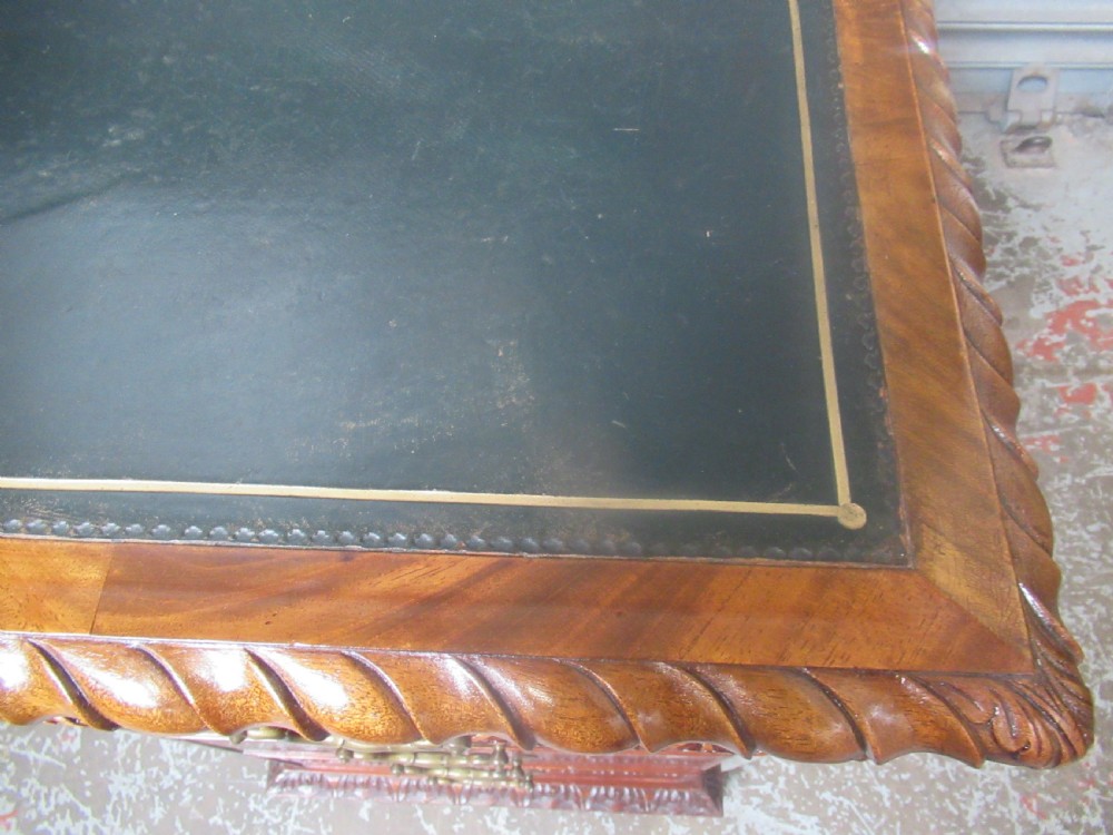 A large mahogany Georgian style pedestal desk featuring a dark green leather writing surface, brass swan-neck handles, and carved rope-twist moulding along the top edge. View IX