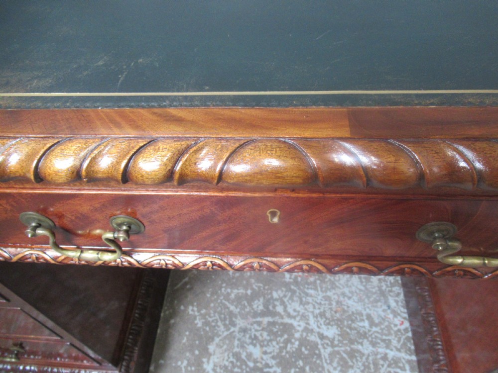 A large mahogany Georgian style pedestal desk featuring a dark green leather writing surface, brass swan-neck handles, and carved rope-twist moulding along the top edge. View XVI