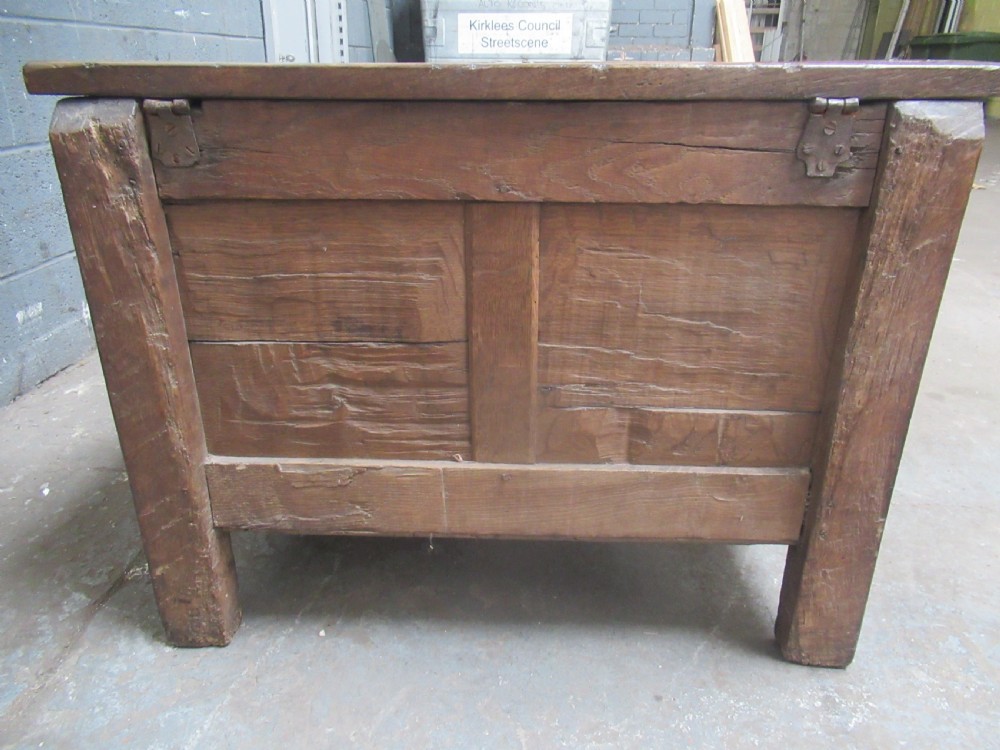 An 18th-century carved oak kist featuring twin front panels with diamond and rosette carvings beneath a lunette-carved top frieze. View VII