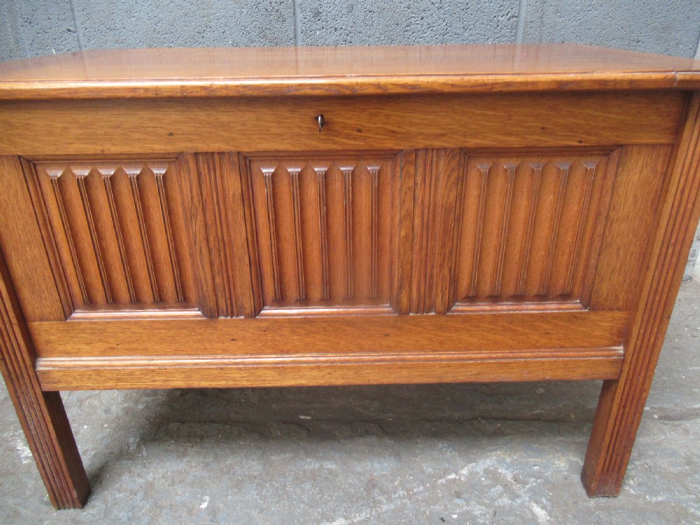 A rectangular light oak blanket box featuring panelled sides, vertical fluted mouldings, and raised block feet. View III