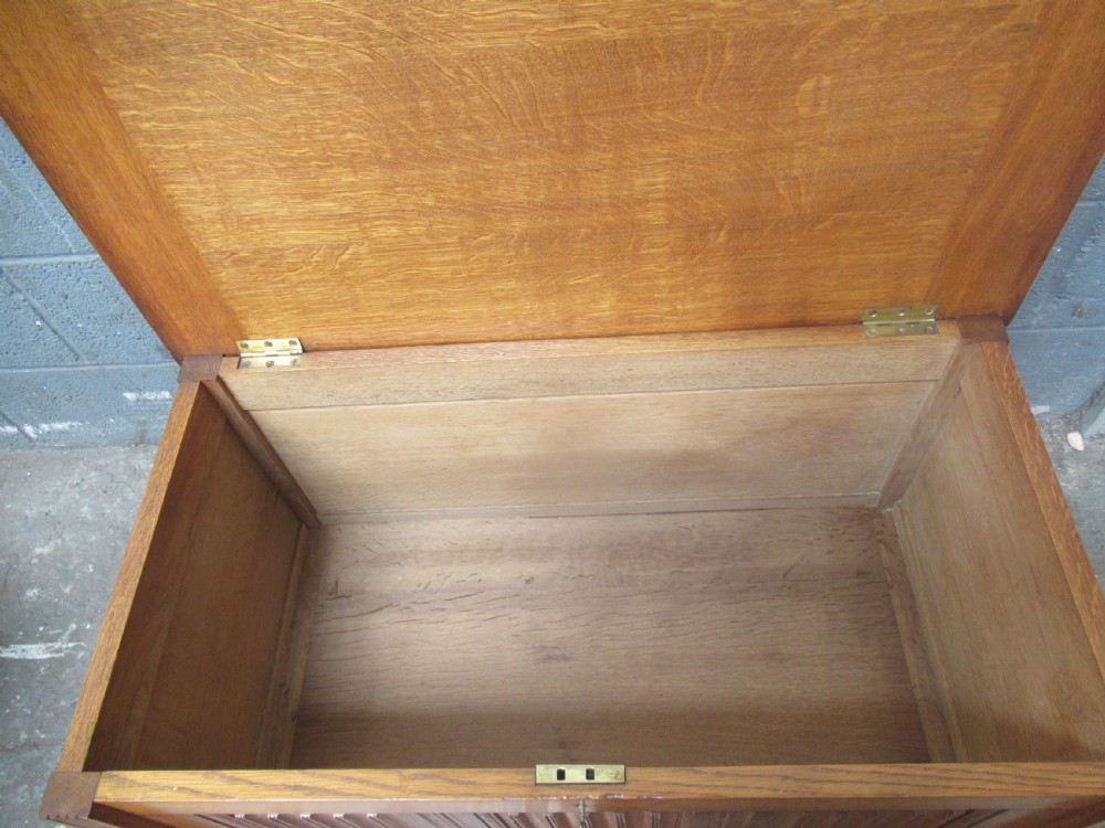 A rectangular light oak blanket box featuring panelled sides, vertical fluted mouldings, and raised block feet. View IV