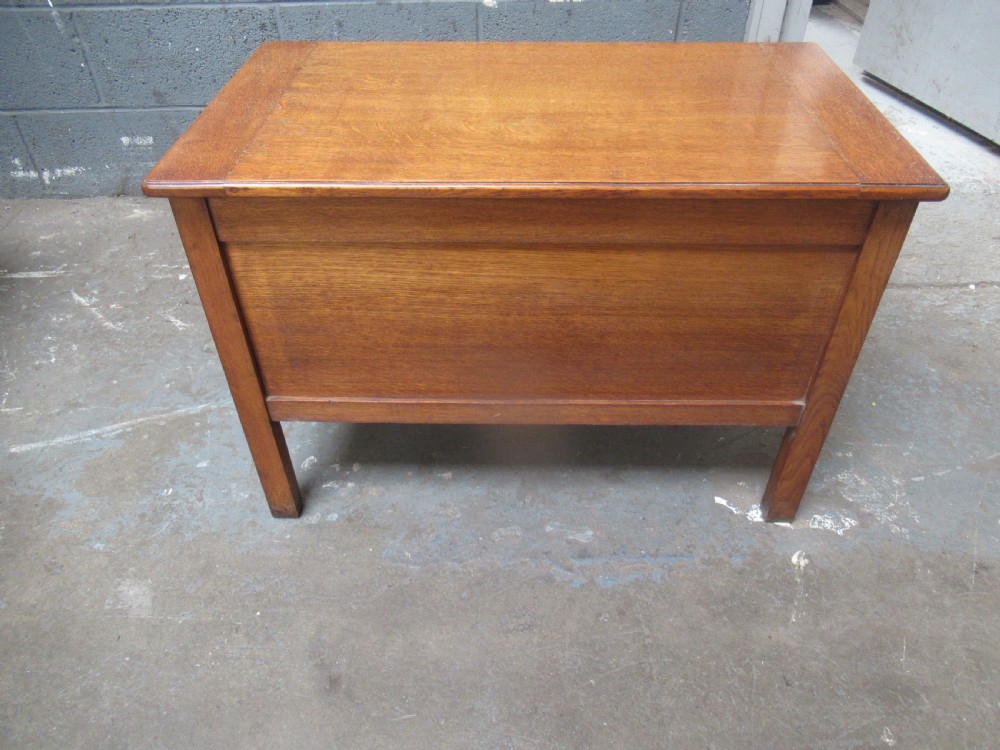 A rectangular light oak blanket box featuring panelled sides, vertical fluted mouldings, and raised block feet. View VII