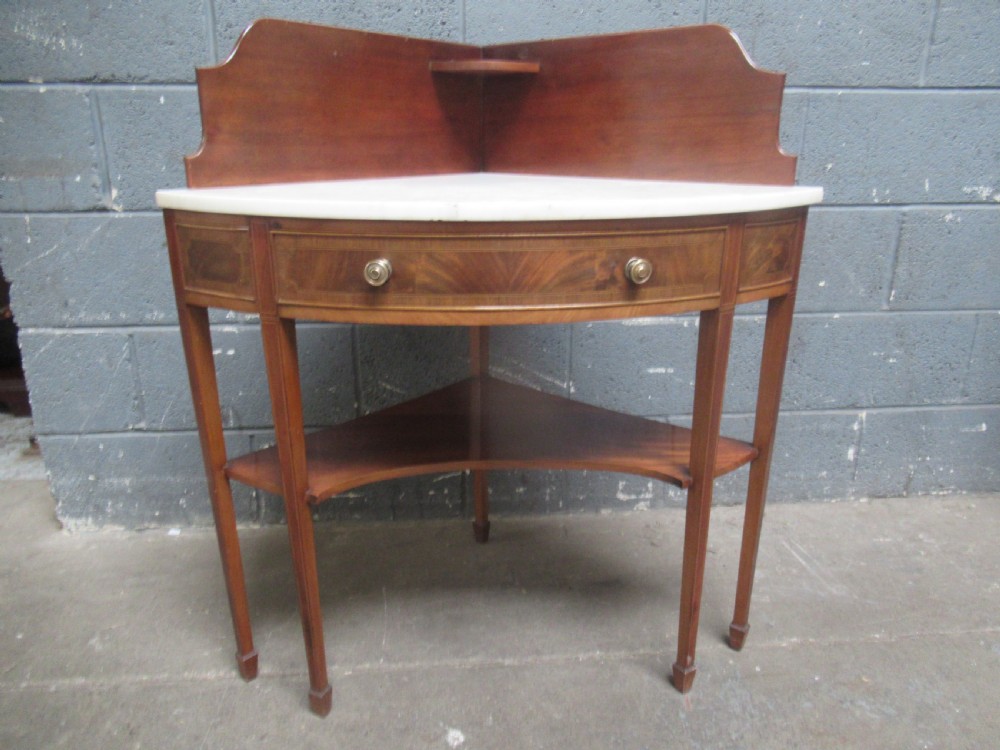 Edwardian mahogany   corner wash stand   with a marble   top.