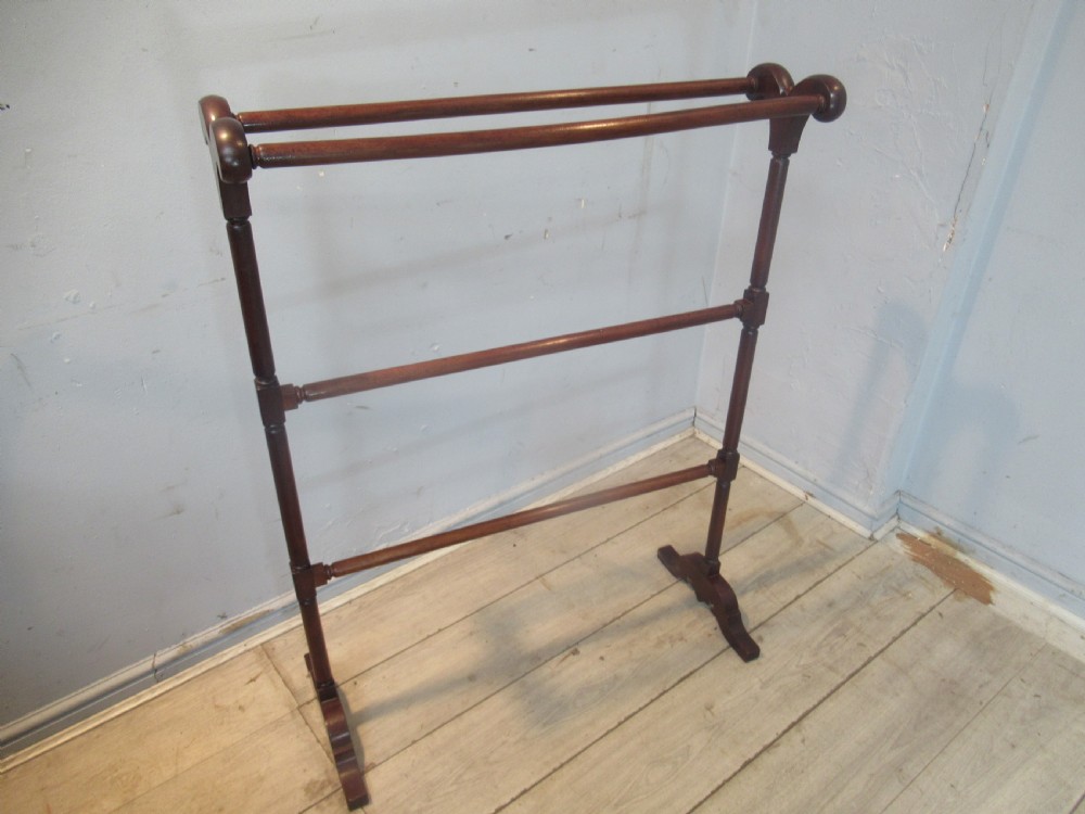 A freestanding dark mahogany Victorian towel rail featuring turned uprights, curved top finials, and shaped trestle feet. View III