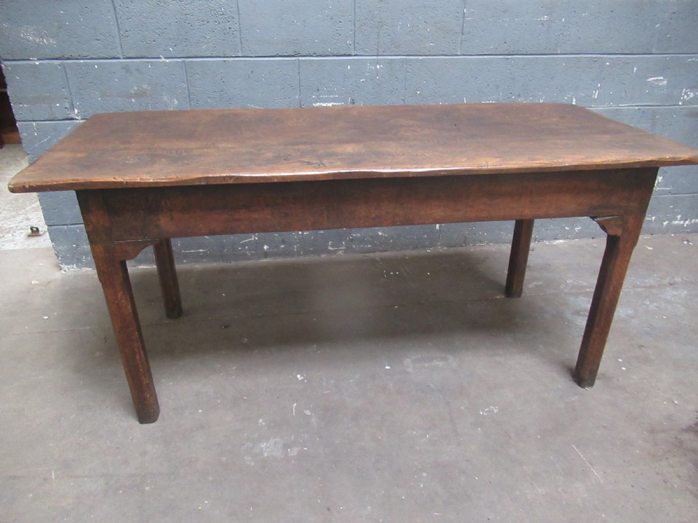 An early 19th-century wooden dining table featuring a rectangular planked top and four sturdy tapering legs. View II